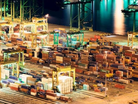 Global trade infrastructure Professional high-resolution nighttime aerial view of a major container terminal, illustrating the scale of global logistics infrastructure.